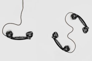 Drei schwarze Telefonhörer auf weißem Grund